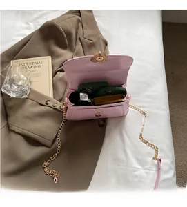 Detail of pink patent leather handbag interior showing space for phones and gold chain strap