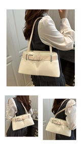 Close-up of minimalist off-white shoulder bag with pink strap and silver buckle detail