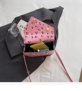 Vue interne du sac à bandoulière rose à motif cerises montrant sa grande capacité
