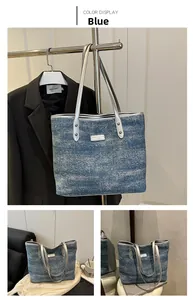 Close-up of blue denim tote bag with silver leather trim and metal brand logo plate