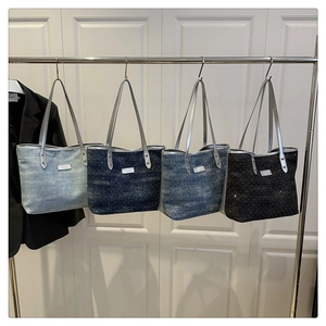 Detail of four denim tote bags with sparkling rhinestones and silver faux leather handles
