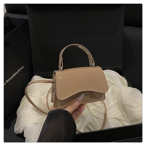 Detail of khaki patent leather mini crossbody bag with wavy flap and silver hardware