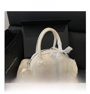 Detail view of white patent leather handbag with lace bow and elegant ribbon decoration