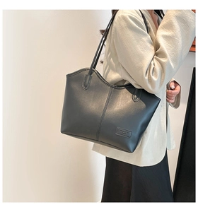 Detail of a black leather tote bag with vertical stitching and Fashion Paris lettering