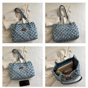 Detail of blue denim tote featuring checkered pattern, frayed edges, and leather strap