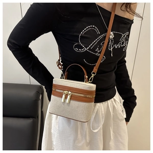 Detail of a vintage box-style shoulder bag with beige canvas and brown leather trim