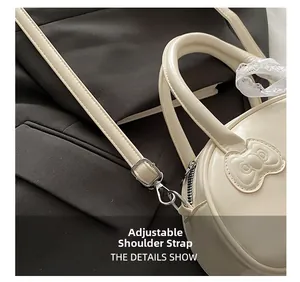 Close-up of the adjustable shoulder strap with metal buckle on the beige handbag