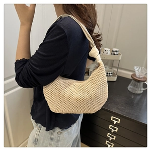 Close-up of beige crochet hobo bag showing woven texture and unique knotted shoulder strap