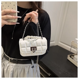 Detailed shot of a white quilted crossbody bag with pearl handle and heart lock