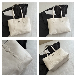 Detail shot of white tote bag featuring embossed cartoon patterns and metal logo plate