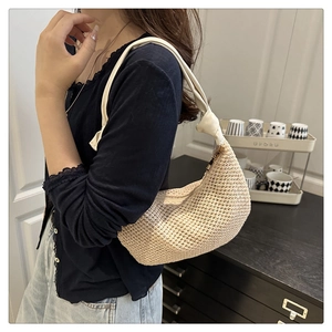 Detail der cremefarbenen Hobo-Tasche mit Häkelstruktur und dekorativem geknotetem Griff