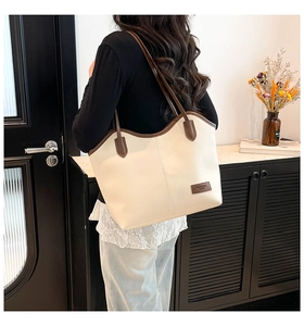 Close-up of cream tote bag with dark brown straps and Fashion Bags leather patch detail