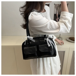Sac à épaule en cuir noir avec deux poches avant et détail de ruban en dentelle blanche
