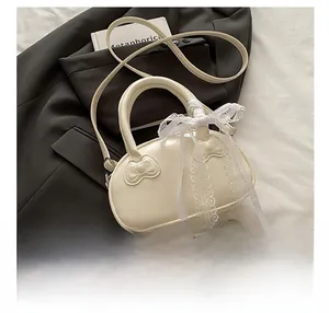 Detail of cream white handbag featuring decorative Sanrio style bows and lace ribbon