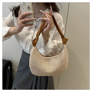 Detailansicht der cremefarbenen Stricktasche mit braunem geknotetem Kunstledergriff