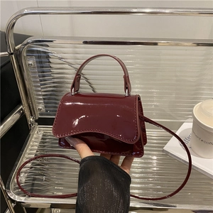 Burgundy patent leather mini crossbody bag with curved base and top handle for women
