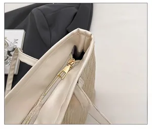 Detail of premium cream tote bag with gold metal zipper and smooth woven texture