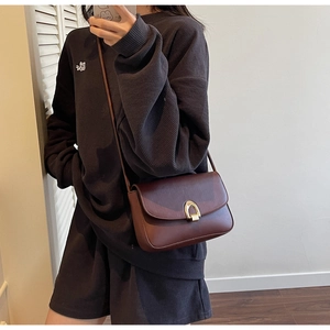 Retro small square leather shoulder bag with gold horseshoe buckle on model