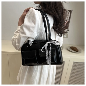 Détail du sac à bandoulière noir en similicuir avec ruban de dentelle blanc et deux poches