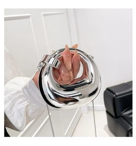 Detail of silver mirror finish mini bag with metal chain and sleek ergonomic handle