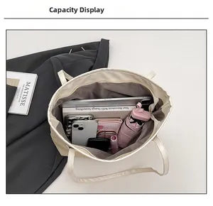 Detail view of large capacity interior showing laptop and essentials in a beige woven tote