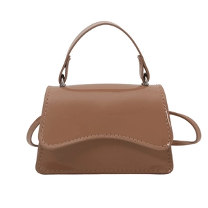 Brown patent leather mini tote bag with wavy flap design and slim shoulder strap