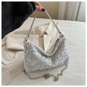 Close-up of shimmering silver sequin crescent bag with metallic chain and zipper detail