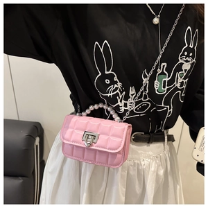 Detail of pink quilted mini bag with pearl handle and silver twist lock on a crossbody chain