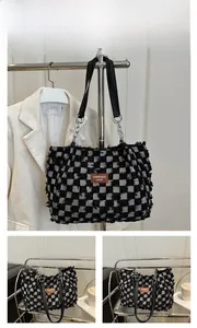Close-up of black and white checkered tote bag with fringe edge and leather label