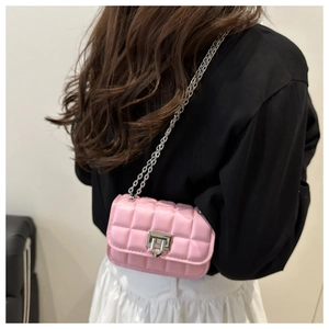 Close-up of pink quilted mini crossbody bag with silver chain and metal turn-lock