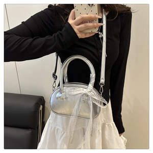 Detail of silver Hello Kitty embossed bag with lace bow and adjustable strap