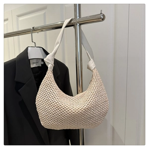 Detail der cremefarbenen Hobo-Tasche mit Flechtstruktur und weißem Lederknotengurt