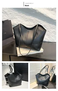 Detail view of large black tote bag featuring vertical stitching and fashion label