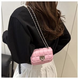 Detail of pink quilted handbag showing pearl chain strap and silver twist lock closure