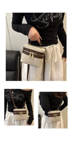 Detail view of canvas handbag with brown leather trim and detachable shoulder strap