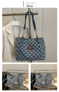 Detailed view of checkered denim tote with frayed texture and brown leather label