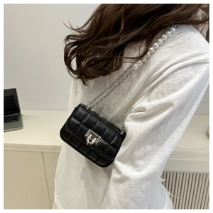 Detail view of black quilted leather shoulder bag with silver lock and pearl chain