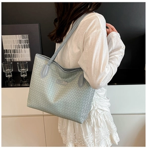 Close-up of light blue woven leather tote bag shoulder strap and fine texture details