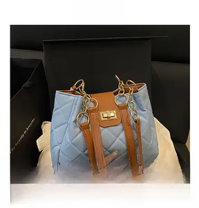 Detail of light blue quilted handbag with gold chain strap in premium gift box