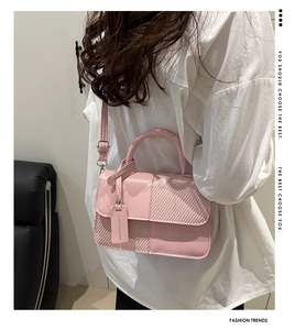 Detail view of pink patchwork crossbody bag with woven texture and fashion tag