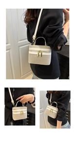 Detailed view of beige woven box bag with white leather trim and metal double zippers