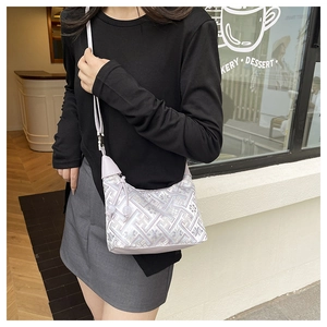 Detail of light purple jacquard crossbody bag with silver floral embroidery and tassels