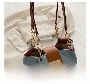 Detail of light blue quilted tote with golden twist lock and brown leather shoulder strap