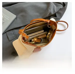 Vista interna della borsa in tela beige che mostra lo spazio per telefono e trucco