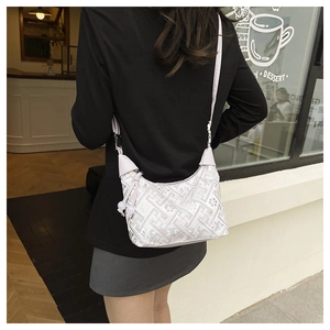 Close-up of crescent-shaped handbag with traditional embroidery on black dress outfit