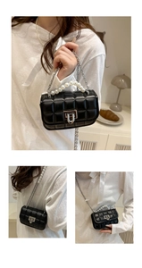 Detail of mini black quilted crossbody bag with pearl handle and silver chain strap