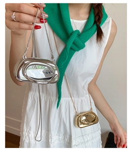Detail of metallic mini crossbody bag with gold and silver finishes and chain straps