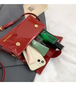 Internal view of burgundy glossy crossbody bag showing spacious storage for cosmetics