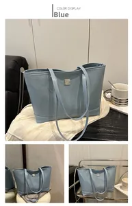 Detail view of light blue tote bag featuring embossed textures and a square metal logo