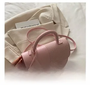 Detail show of pink leather and woven patchwork crossbody bag with metal buckle